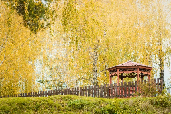 Overdekt prieel om te ontspannen met houten hek op de heuvel op een herfst dag. — Stockfoto