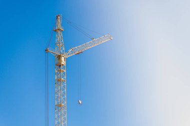 Mavi gökyüzüne karşı büyük evlerin inşaatı için uzun bom ile Inşaat vinç.