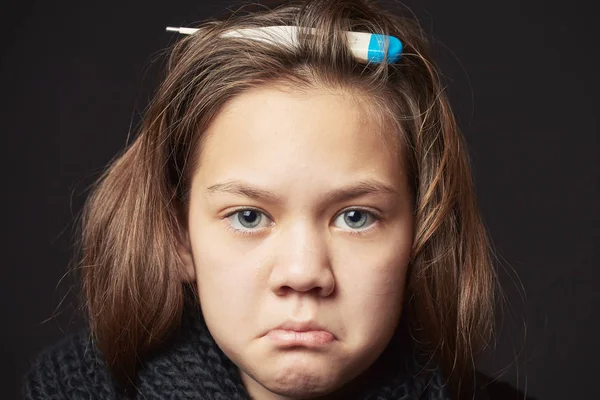 Retrato de niña con grandes ojos y termómetro para medir la temperatura en la cabeza en su cabello . — Foto de Stock