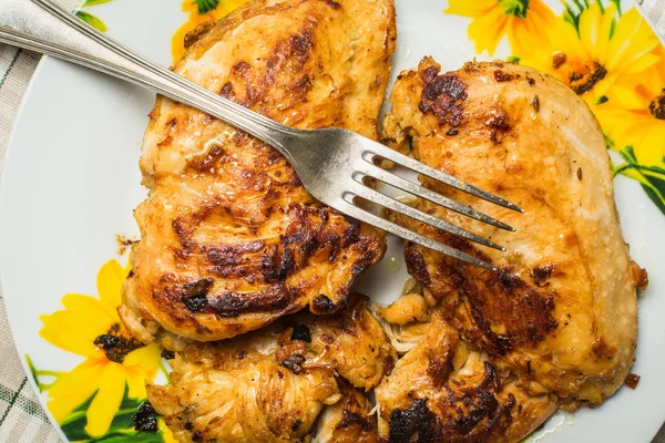 Fillet dada ayam goreng juicy dengan garpu meja di piring di meja dapur . — Stok Foto