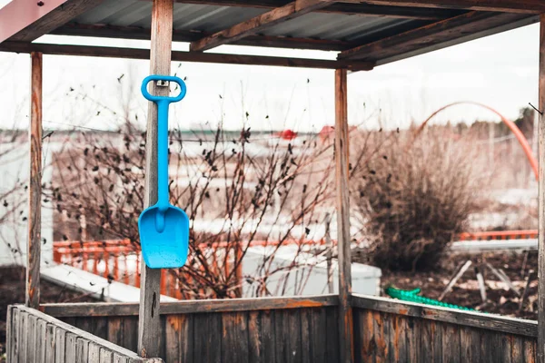 Oyunlar ve çocuk gelişimi için çocuk oyuncak mavi kürek kum havuzunda asılı. — Stok fotoğraf