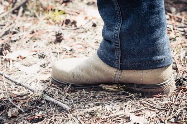 De benen van het meisje in jeans en speciale laarzen gaan op bosgebied in wandeltocht. — Stockfoto