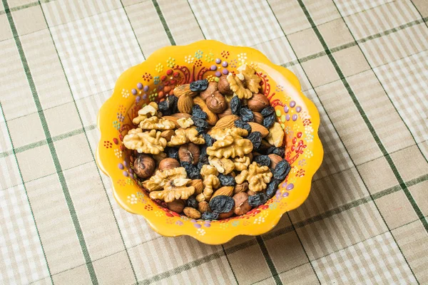 Mixture of different nuts and raisins in beautiful plate.