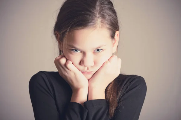 Offended girl with gloomy eyes and hands at the chin. — Stock Photo, Image