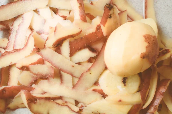 Purified skin of shallow potatoes with special knife on sink. — Stock Photo, Image