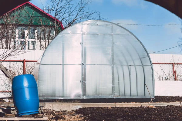 Greenhouse for growing flowers and vegetables from polycarbonate installed in garden. — Stock Photo, Image