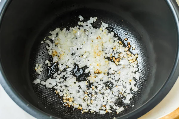 Cebolla en rodajas frita en cuenco multicocción para cocinar . —  Fotos de Stock