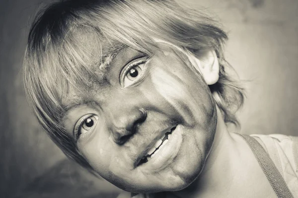 Niño pequeño con ojos grandes y cara pintada . —  Fotos de Stock