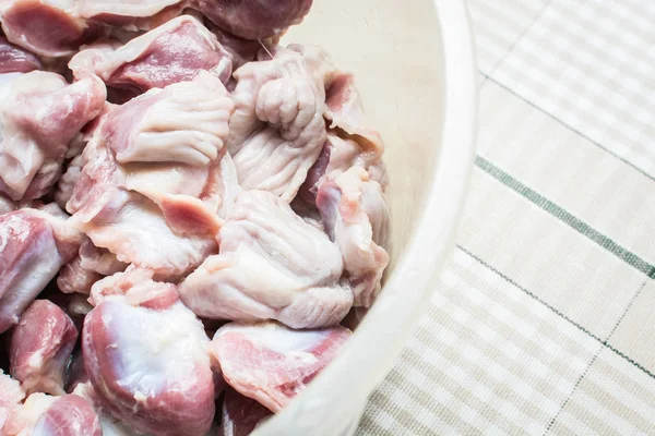 Thawed and washed chicken gizzards in eggplant on the kitchen table for cooking soup. — Stock Photo, Image