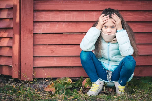 Vacker flicka sitter nära den röda Arbor. — Stockfoto