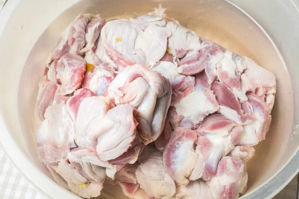 Thawed and washed chicken gizzards in eggplant on the kitchen table for cooking soup. — Stock Photo, Image