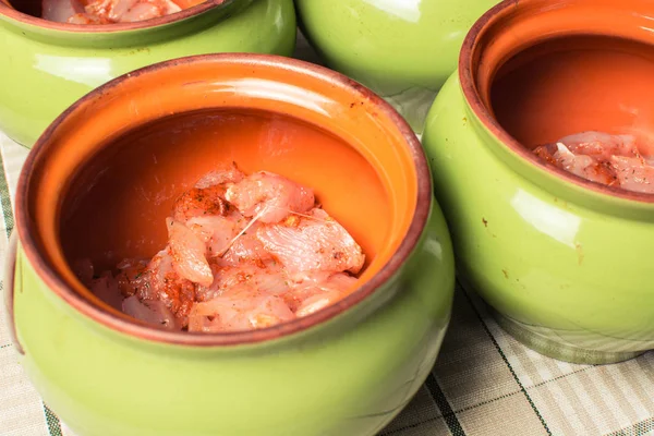 Raw sliced chicken breast fillets in ceramic pot for cooking in the oven. — Stock Photo, Image