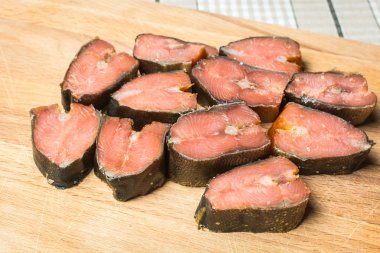 Füme balık pembe somon ahşap kesme tahtası üzerinde dilimlenmiş.