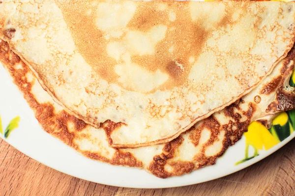 Panqueques amarillos para el desayuno en plato grande sobre tabla de madera . — Foto de Stock