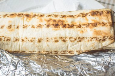 Taze et ve sebze shawarma pide ekmek sarılmış tabakta yatıyor