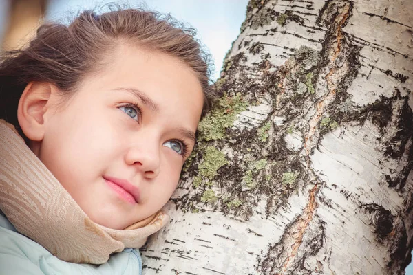 รูปภาพที่สวยงามของเด็กสาวที่มีผมยาวในแจ็คเก็ตสีฟ้าลงที่เบิร์ชในวันฤดูใบไม้ร่วง . — ภาพถ่ายสต็อก
