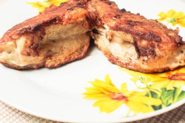 Mutfak masasında tabakta pişmiş kızarmış levrek.