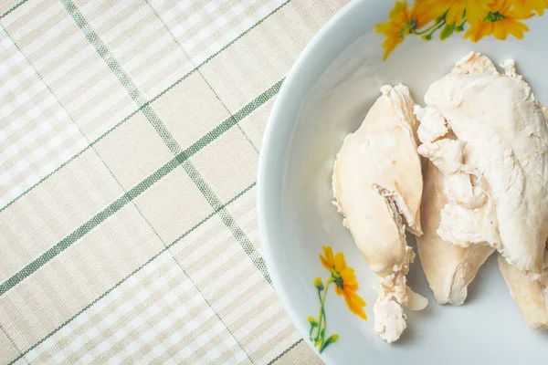 Big pieces of boiled chicken in deep plate on kitchen table. — Stock Photo, Image