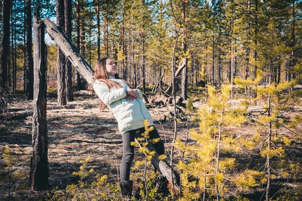 ハイキングの後に軽いジャケットに身を包んだ女の子は嘘と松の森の中で古いスナックに残ります. — ストック写真