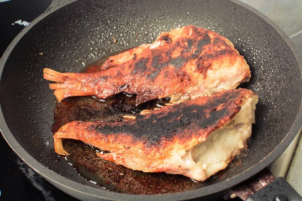 Ikan laut merah digoreng dalam penggorengan di atas kompor . — Stok Foto