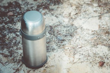 Ormanda yürüyüş gezisi sırasında ısınmak için kapalı çay termos.