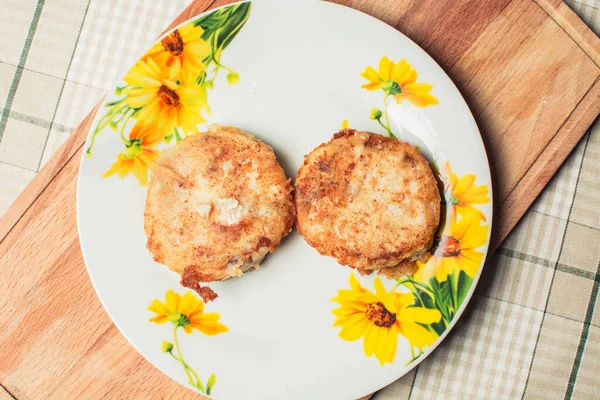 Gebakken ronde heek visfilets in plaat op keuken tafel. — Stockfoto