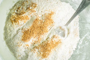 Derin kasede ekmek kırıntıları ve karıştırıcı kaşıkla beyaz un..