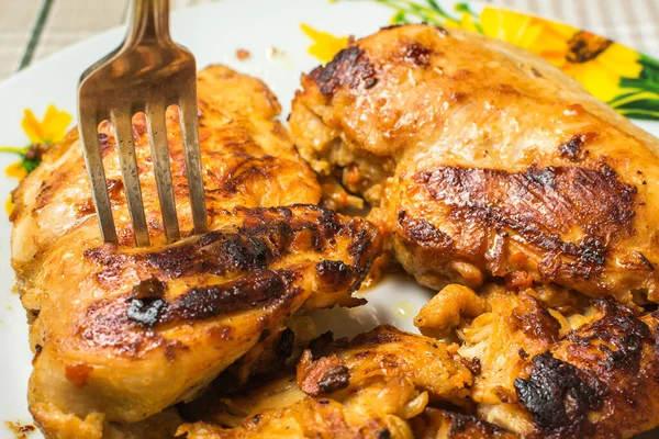 Filé de peito de frango frito suculento com garfo de mesa em uma placa na mesa da cozinha . — Fotografia de Stock