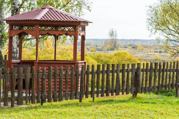 Gazebo de madera para relajarse con valla en la colina en un día de otoño . —  Fotos de Stock