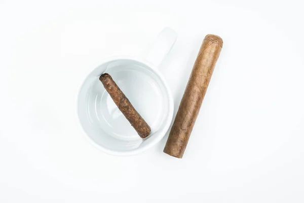 Brown cigars from twisted sheets in mug with white background. — Stock Photo, Image