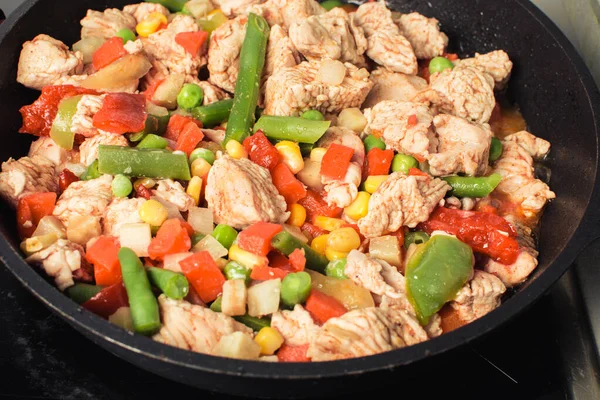 Roasted soft chicken pieces with vegetable mixture in pan. Stock Photo