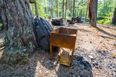 Siyah spor sırt çantası ormanda paslı barbekü için çok pahalı.