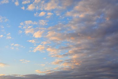 Günbatımında süzülen beyaz bulutlarla akşam gökyüzü. Arkaplan