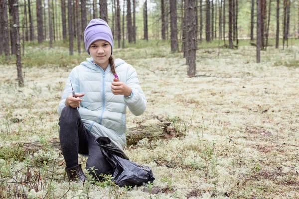 秋の日に松の森で手にナイフとキノコのボレトスと満足した女の子 — ストック写真