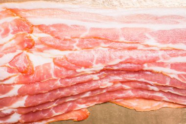 Mutfak masasında ince dilimlenmiş domuz pastırması.