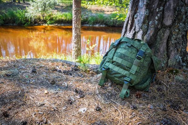 Khaki Σακίδιο Βρίσκεται Στην Όχθη Του Ποταμού Κωνοφόρα Καλοκαιρινό Δάσος — Φωτογραφία Αρχείου