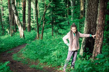Ormandaki tatlı kız ağaçların arasında geziniyor.