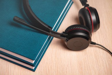 İki defterde mikrofon olan kulaklıklar. Kavram çağrı uzaklığı