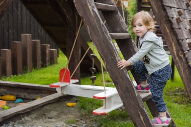 Küçük çocuk oyun alanında oynuyor.