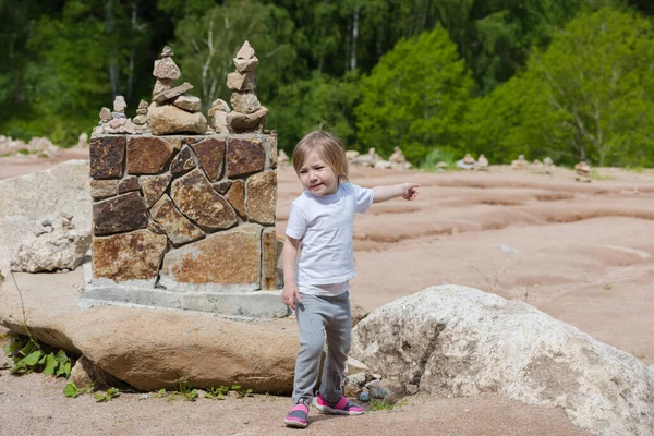 子供の女の子は夏の日に山に行く方向を示しています — ストック写真