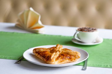 Bir restoranda ayrılmış bir masada peynir ile Khachapuri Penovani.