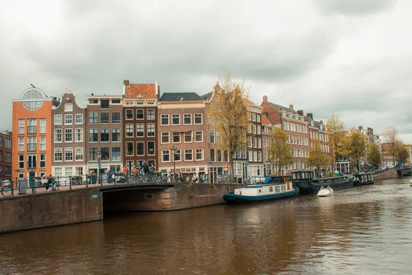 Průplav, domy a motorkáři v amsterdamském městském centru — Stock fotografie