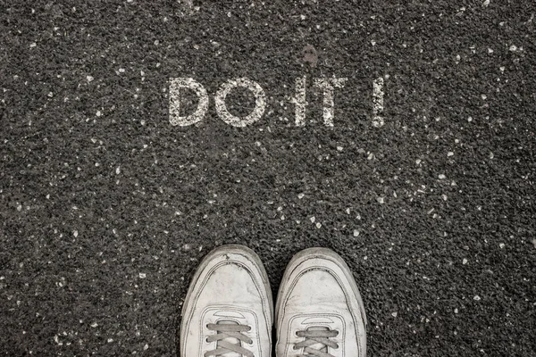 Neues Lebenskonzept, motivierender Slogan mit Wort do it! auf dem Boden von Asphalt — Stockfoto