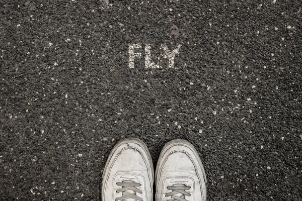Nuevo concepto de vida, lema motivacional con Word FLY en el suelo de asfalto —  Fotos de Stock