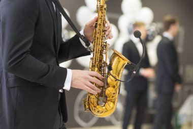 Saksafon oynamaya sırasında müzisyenin ellerine.