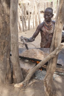 Vadi Omo, Etiyopya, 15 Mart 2012: Yaşlı Karo kadın sorgum Colcho, Omo Vadisi, Etiyopya, geleneksel bira bira için hazırlar. Ev işi tüm Karo kadınlar için bir görevidir.
