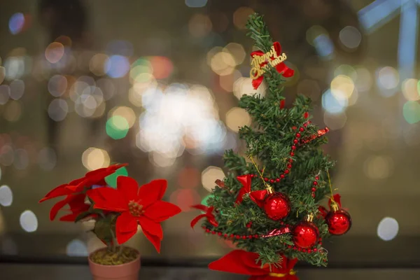 Artificial Christmas tree and night city lights.