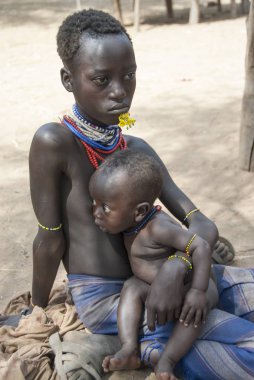 Colcho, Etiyopya, 17 Mart 2012: Tanımlanamayan Karo kız kardeşi ile Colcho, vadi Omo, Etiyopya'da turistler için bekler. Birçok yerel çocuk okulda eğitim yerine yalvarıyor nişanlandık.