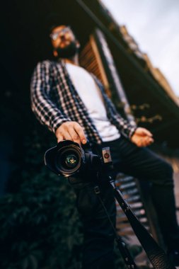 Kamera, fotoğrafçının elinde. Yakın çekim ve odaklanma. Elinde kamera olan bir fotoğrafçı şehrin sokaklarını yakalıyor. Fotoğrafçı Konsepti