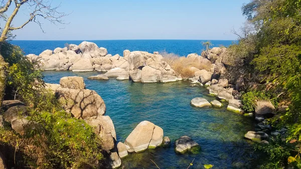 a small bay with large boulders sticking out of the water.